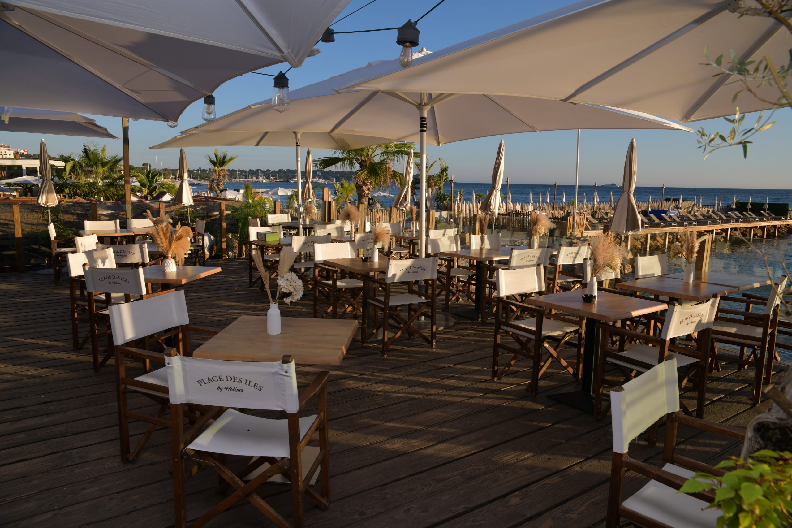 Déjeuner en terrasse au restaurant Plage des Îles avec vue imprenable sur le ponton et la mer.